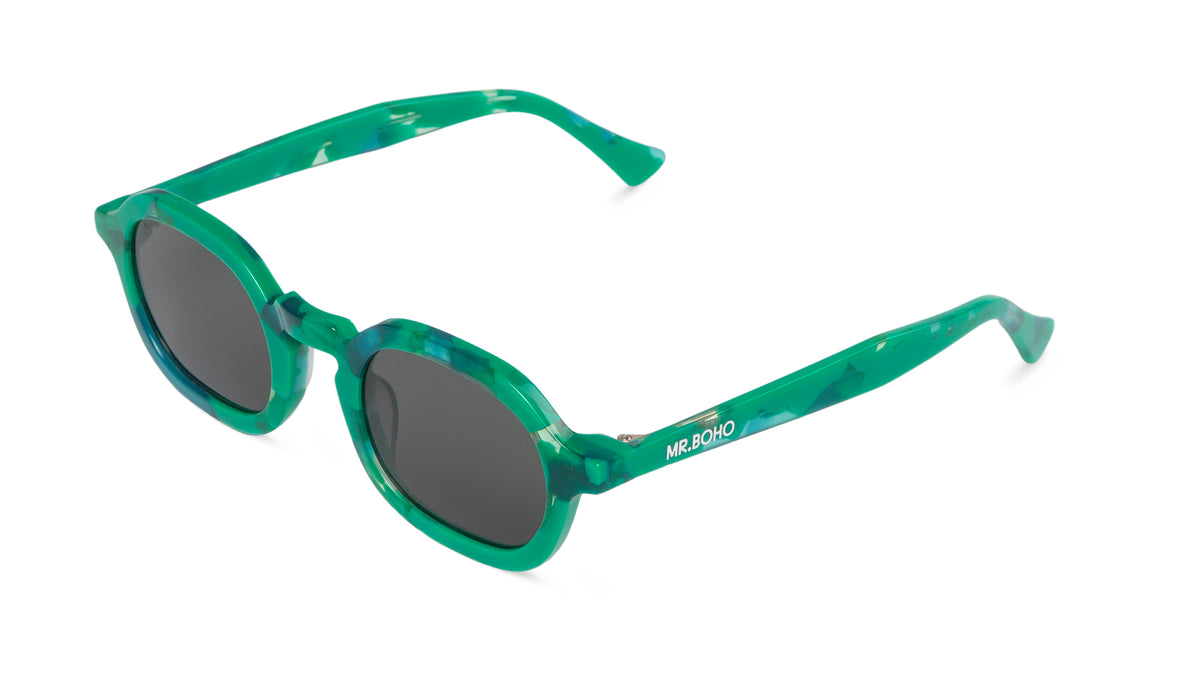 A pair of green mosaic pattern-framed oval sunglasses with dark lenses. - arial view