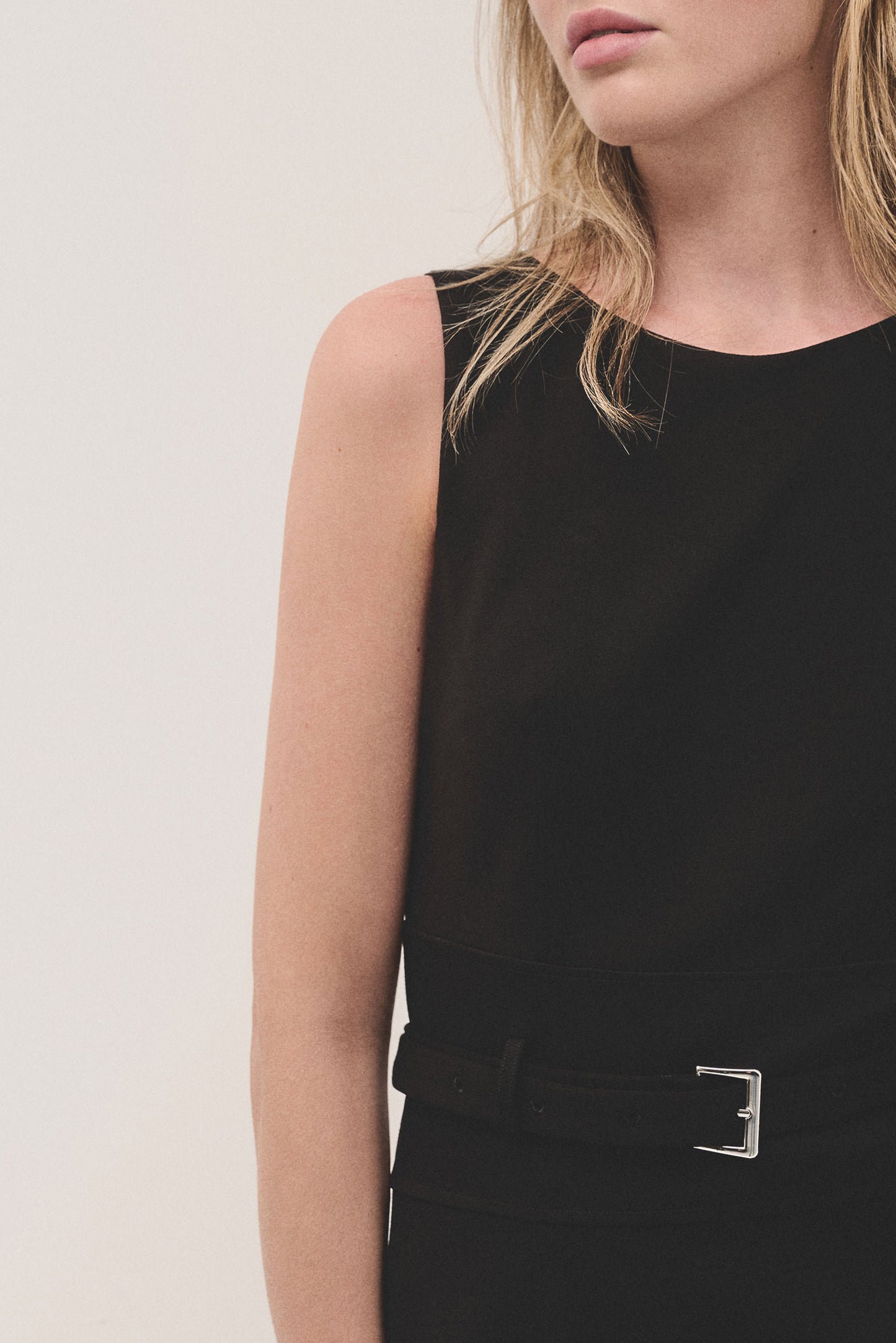 Black sleeveless dress with belt in cut knitted fabric