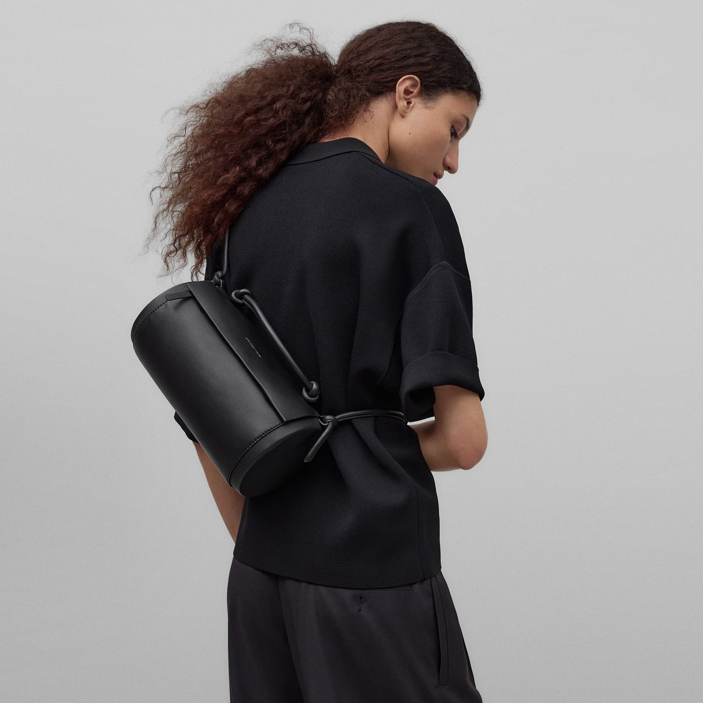 Black cylindrical leather bag woman in black