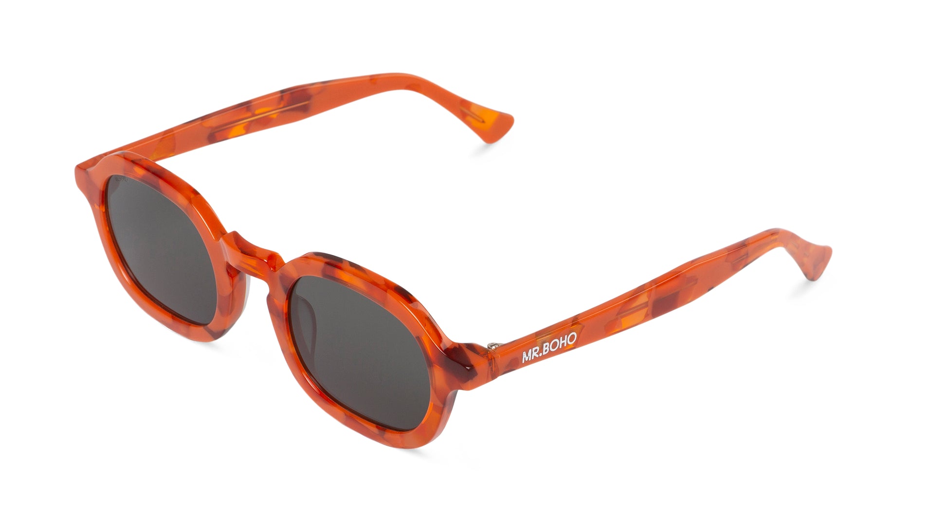 A pair of orange mosaic pattern-framed oval sunglasses with dark lenses. 0 arial view