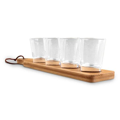Set of four clear glasses on a wooden tray with a white background