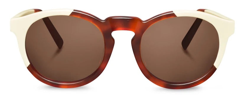 Rounded sunglasses with tortoiseshell frame, white corners and brown lenses on a white background